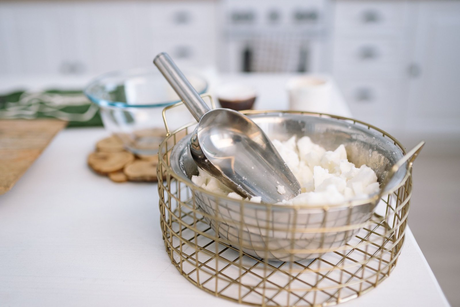 Close-up of a metal bowl with wax and a scoop, essential for candle making.